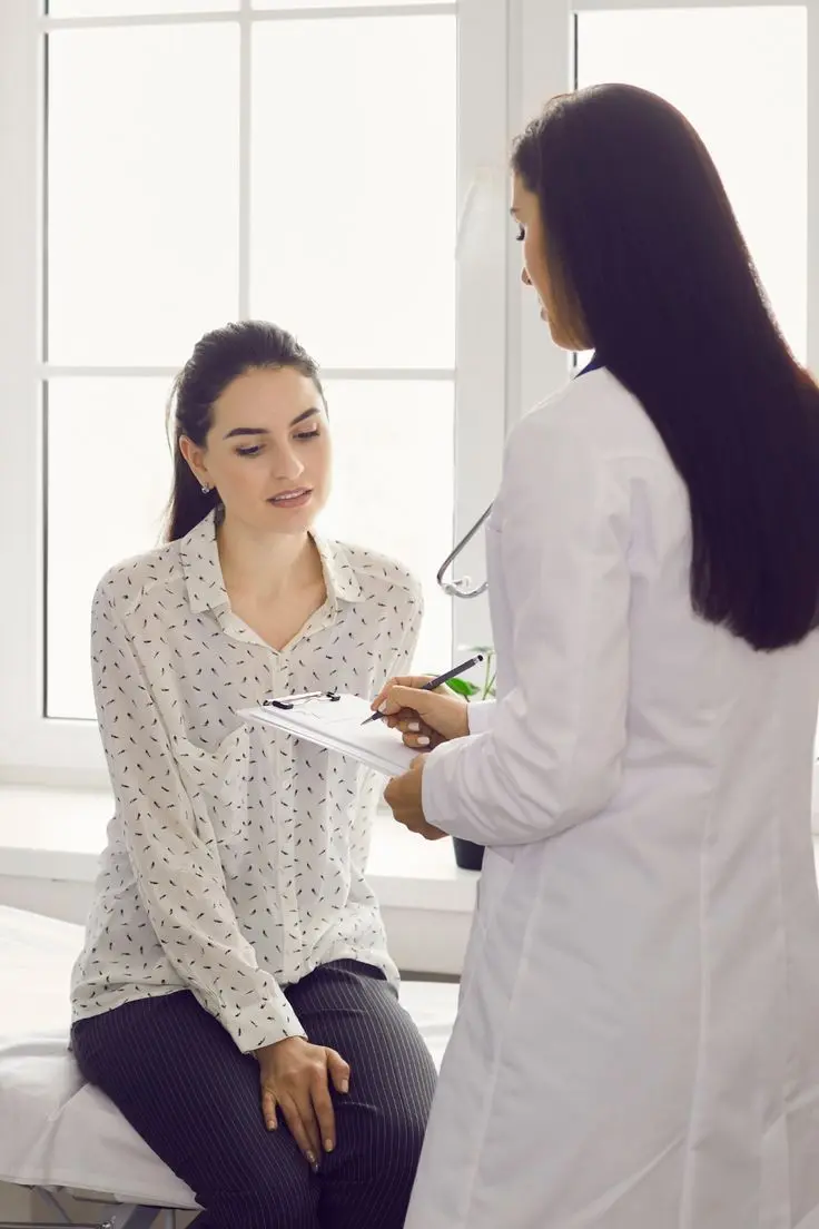 Profissional de saúde orientando uma paciente em consultório