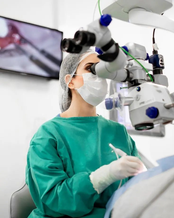 Profissional realizando procedimento odontológico com tecnologia de ampliação